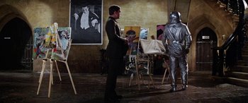 Movie still from “The Ninth Configuration” (1980), directed by William Peter Blatty – A man standing in front of an easel in a room; Medium shot, Low angle