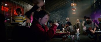 Movie still from “The Ninth Configuration” (1980), directed by William Peter Blatty – A group of people sitting at a table with drinks; Medium shot, Over the shoulder angle