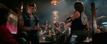 Movie still from “The Ninth Configuration” (1980), directed by William Peter Blatty – A group of men standing in a room; Medium shot, Over the shoulder angle
