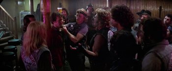 Movie still from “The Ninth Configuration” (1980), directed by William Peter Blatty – A group of people standing around each other in a room; Medium shot, Over the shoulder angle