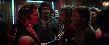 Movie still from “The Ninth Configuration” (1980), directed by William Peter Blatty – A group of men standing next to each other in a room; Medium shot, Over the shoulder angle