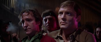 Movie still from “The Ninth Configuration” (1980), directed by William Peter Blatty – A group of men standing next to each other in a room; Close Up shot, Low angle