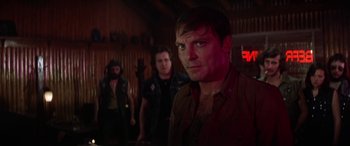 Movie still from “The Ninth Configuration” (1980), directed by William Peter Blatty – A group of men standing next to each other in a room; Medium shot, Over the shoulder angle