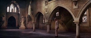 Movie still from “The Ninth Configuration” (1980), directed by William Peter Blatty – A man in a military uniform standing in front of an archway; Wide shot, High angle