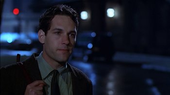 Movie still from “The Object of My Affection” (1998), directed by Nicholas Hytner – A man wearing a suit and tie standing in the dark; Close Up shot, Low angle