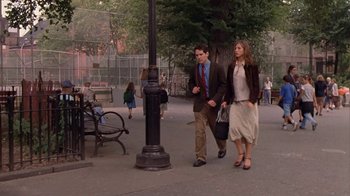 Movie still from “The Object of My Affection” (1998), directed by Nicholas Hytner – A man and a woman are walking on the sidewalk; Wide shot, High angle