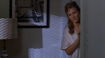 Movie still from “The Object of My Affection” (1998), directed by Nicholas Hytner – A woman leaning against a wall in a room; Medium shot, High angle