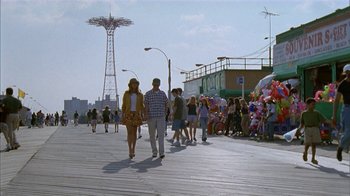 Movie still from “The Object of My Affection” (1998), directed by Nicholas Hytner – A group of people walking on a boardwalk near a ferris wheel; Wide shot, Low angle