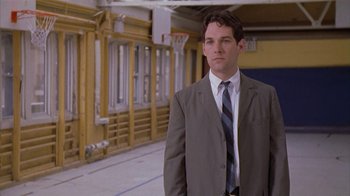 Movie still from “The Object of My Affection” (1998), directed by Nicholas Hytner – A man wearing a suit and tie standing in a room; Medium shot, Low angle