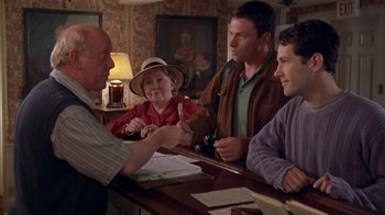 Movie still from “The Object of My Affection” (1998), directed by Nicholas Hytner – A group of people sitting around a table; Medium shot, Over the shoulder angle