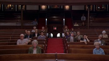 Movie still from “The Object of My Affection” (1998), directed by Nicholas Hytner – A group of people sitting in pews in a church; Wide shot, High angle