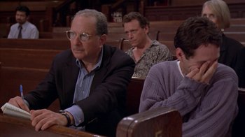 Movie still from “The Object of My Affection” (1998), directed by Nicholas Hytner – Three men sitting in a church pews , one of whom is smoking a cigarette; Medium shot, High angle