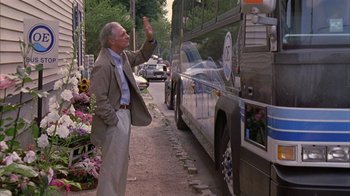Movie still from “The Object of My Affection” (1998), directed by Nicholas Hytner – An older man waves goodbye to a bus driver; Wide shot, Over the shoulder angle