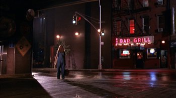Movie still from “The Object of My Affection” (1998), directed by Nicholas Hytner – A woman is standing on the corner of a street at night; Wide shot, Low angle
