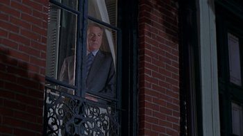 Movie still from “The Object of My Affection” (1998), directed by Nicholas Hytner – An older man in a suit looking out of a window; Wide shot, Low angle