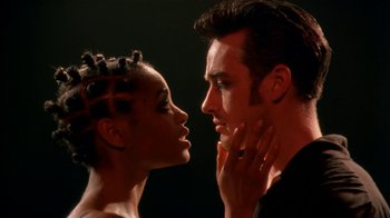 Movie still from “The Object of My Affection” (1998), directed by Nicholas Hytner – A man and a woman face to face in front of a black background; Close Up shot, Low angle