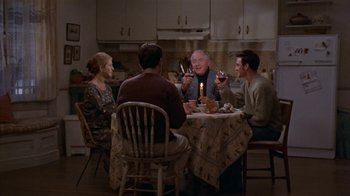 Movie still from “The Object of My Affection” (1998), directed by Nicholas Hytner – A group of people sitting around a table drinking wine; Wide shot, High angle