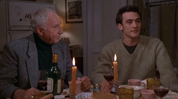 Movie still from “The Object of My Affection” (1998), directed by Nicholas Hytner – A group of people sitting at a dinner table with candles; Medium shot, High angle