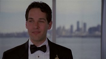 Movie still from “The Object of My Affection” (1998), directed by Nicholas Hytner – A man wearing a tuxedo and a bow tie in front of a city skyline; Close Up shot, Low angle