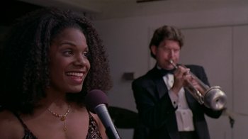 Movie still from “The Object of My Affection” (1998), directed by Nicholas Hytner – A man and a woman are singing into microphones; Close Up shot, Low angle