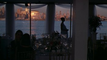 Movie still from “The Object of My Affection” (1998), directed by Nicholas Hytner – A man standing in front of a window with a view of a city; Extreme Wide shot, High angle