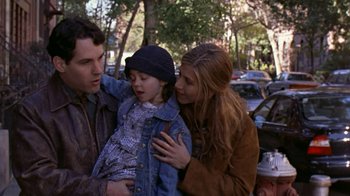 Movie still from “The Object of My Affection” (1998), directed by Nicholas Hytner – A man and a woman holding a little girl in her arms; Medium shot, High angle