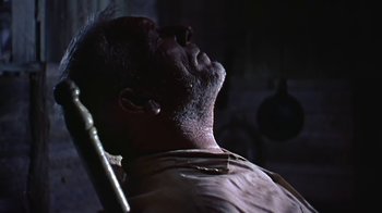 Movie still from “The Old Man and the Sea” (1958), directed by Fred Zinnemann – An old man with a beard is sitting in a dentist chair; Close Up shot, Low angle
