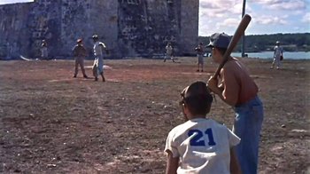 Movie still from “The Old Man and the Sea” (1958), directed by Fred Zinnemann – A group of young men playing a game of baseball; Wide shot, Over the shoulder angle