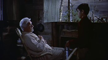 Movie still from “The Old Man and the Sea” (1958), directed by Fred Zinnemann – An older man sitting next to a young woman; Medium shot, High angle
