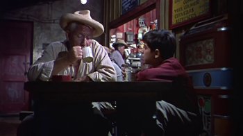 Movie still from “The Old Man and the Sea” (1958), directed by Fred Zinnemann – A man and a boy sitting at a table; Medium shot, Over the shoulder angle
