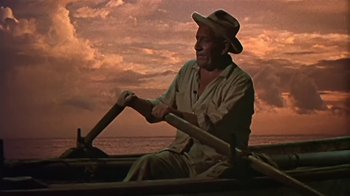 Movie still from “The Old Man and the Sea” (1958), directed by Fred Zinnemann – A man rowing a boat on the ocean at sunset; Medium shot, Low angle