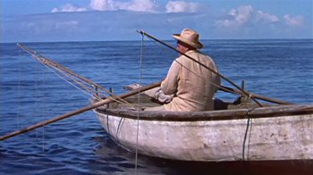 Movie still from “The Old Man and the Sea” (1958), directed by Fred Zinnemann – An old man in a hat is sitting in a small boat; Wide shot, High angle