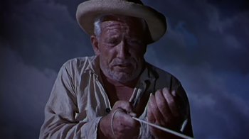 Movie still from “The Old Man and the Sea” (1958), directed by Fred Zinnemann – An old man in a hat is holding a fishing rod; Close Up shot, Low angle