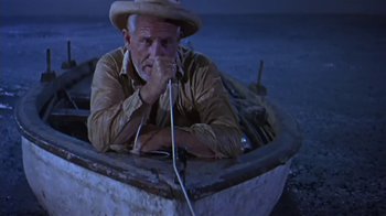 Movie still from “The Old Man and the Sea” (1958), directed by Fred Zinnemann – An older man in a boat with a hat on; Medium shot, High angle