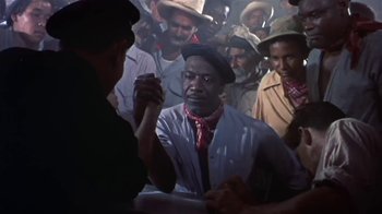 Movie still from “The Old Man and the Sea” (1958), directed by Fred Zinnemann – A group of men standing around each other in a room; Medium shot, High angle