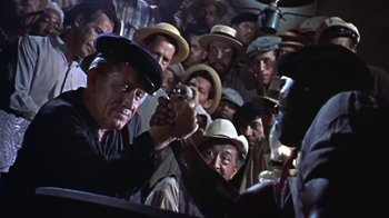 Movie still from “The Old Man and the Sea” (1958), directed by Fred Zinnemann – A group of men in hats are holding guns; Medium shot, Low angle