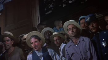 Movie still from “The Old Man and the Sea” (1958), directed by Fred Zinnemann – A group of men standing next to each other wearing straw hats; Medium shot, Low angle