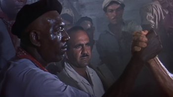 Movie still from “The Old Man and the Sea” (1958), directed by Fred Zinnemann – A group of men standing next to each other in a room; Close Up shot, Low angle