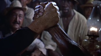 Movie still from “The Old Man and the Sea” (1958), directed by Fred Zinnemann – Two people are holding hands in the middle of a crowd; Close Up shot, High angle