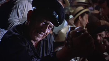 Movie still from “The Old Man and the Sea” (1958), directed by Fred Zinnemann – An old man wearing a black hat is smiling for the camera; Close Up shot, Low angle