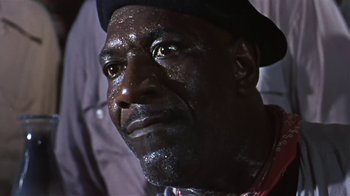 Movie still from “The Old Man and the Sea” (1958), directed by Fred Zinnemann – A person wearing a hat and looking at the camera; Close Up shot, Low angle