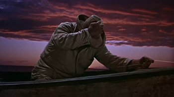 Movie still from “The Old Man and the Sea” (1958), directed by Fred Zinnemann – A man sitting on top of a boat on top of a body of water; Medium shot, Low angle