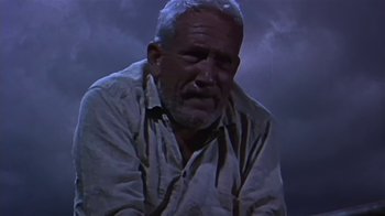 Movie still from “The Old Man and the Sea” (1958), directed by Fred Zinnemann – An older man sitting in front of a cloudy sky; Medium shot, Low angle