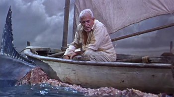 Movie still from “The Old Man and the Sea” (1958), directed by Fred Zinnemann – An old man sitting on a boat in the water; Wide shot, Low angle