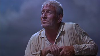 Movie still from “The Old Man and the Sea” (1958), directed by Fred Zinnemann – An old man with a gray beard is looking up; Medium shot, Low angle