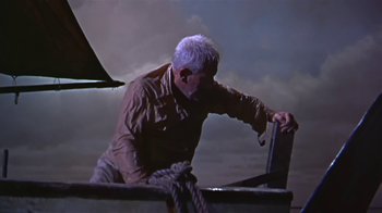 Movie still from “The Old Man and the Sea” (1958), directed by Fred Zinnemann – An older man is standing on the deck of a boat; Wide shot, High angle