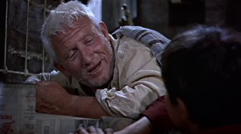 Movie still from “The Old Man and the Sea” (1958), directed by Fred Zinnemann – An older man is crying while holding a young child; Medium shot, Low angle