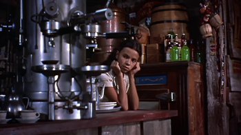Movie still from “The Old Man and the Sea” (1958), directed by Fred Zinnemann – A woman sitting at a counter in front of pots and pans; Medium shot, High angle