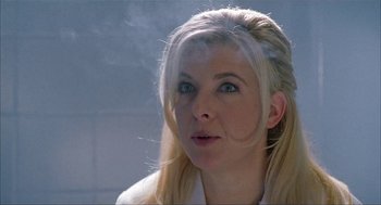 Movie still from “The One and Only” (1999), directed by Susanne Bier – A woman with blonde hair is smoking a cigarette; Close Up shot, Over the shoulder angle