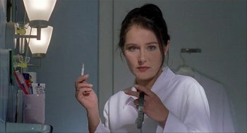 Movie still from “The One and Only” (1999), directed by Susanne Bier – A woman is holding a cigarette and wearing a white shirt; Close Up shot, Low angle